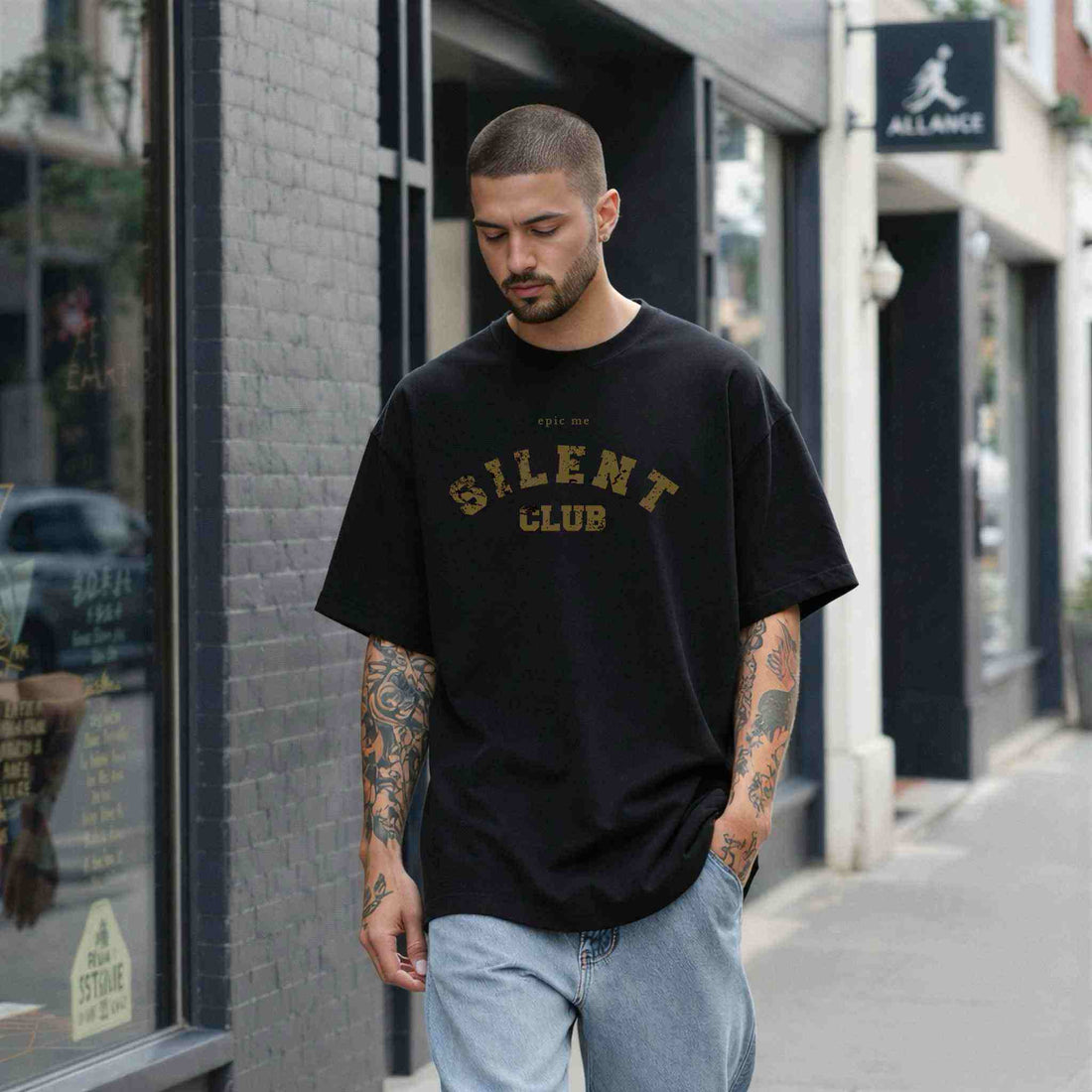 Hombre con camiseta holgada negra y vaqueros claros en un look casual urbano