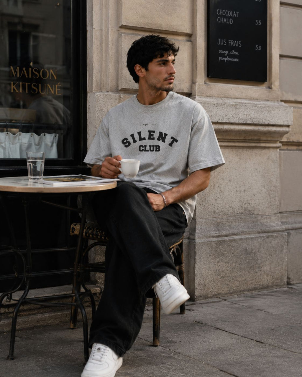 Hombre con camiseta gris boxy fit corte cuadrado streetwear Epic Me en café urbano