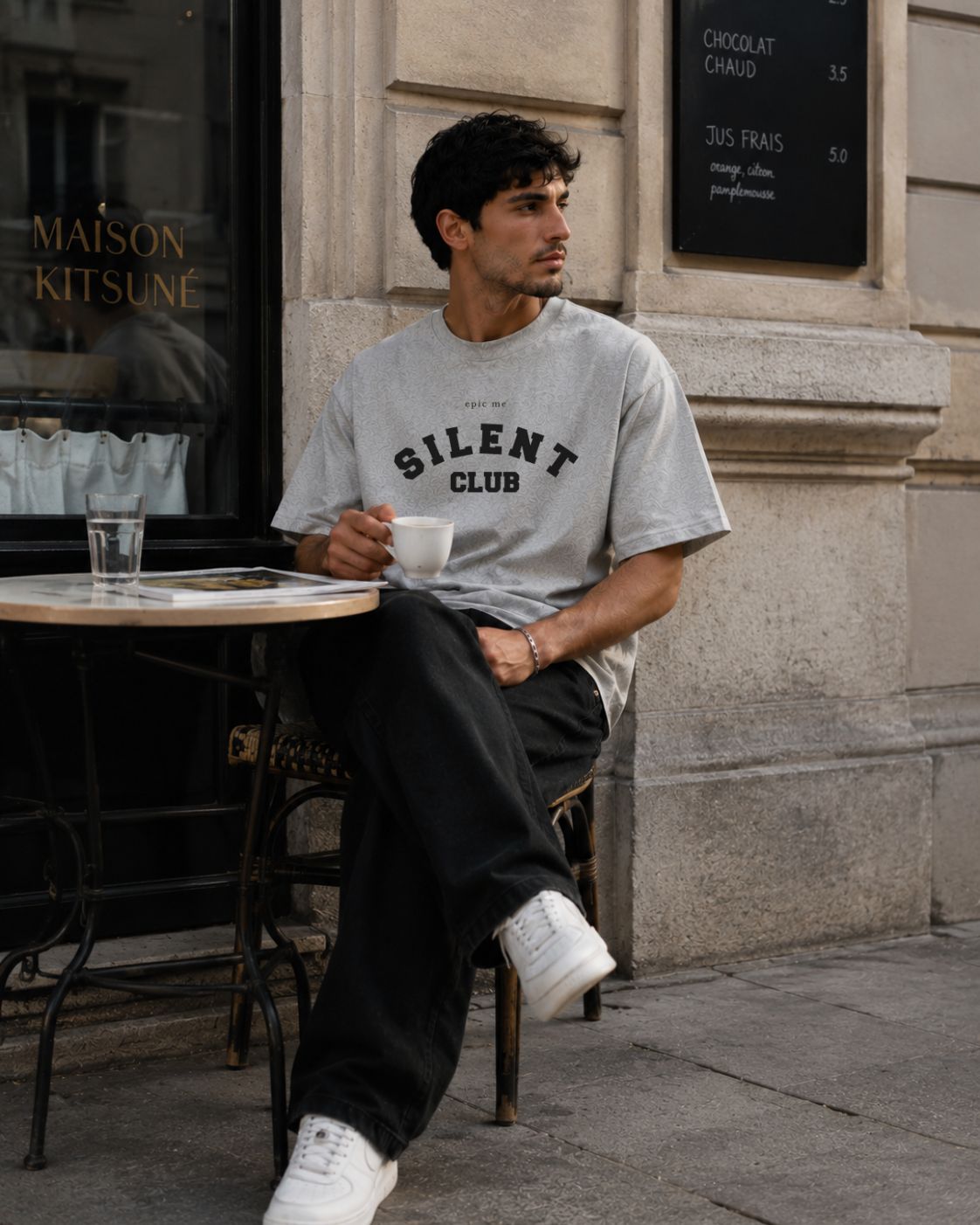 Hombre con camiseta gris boxy fit corte cuadrado streetwear Epic Me en café urbano