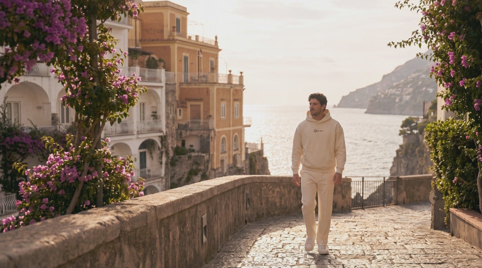 Hombre paseando por la Costa Amalfitana con un chándal beige de streetwear premium Epic Me, con el texto Moda urbana para quienes no se visten para encajar